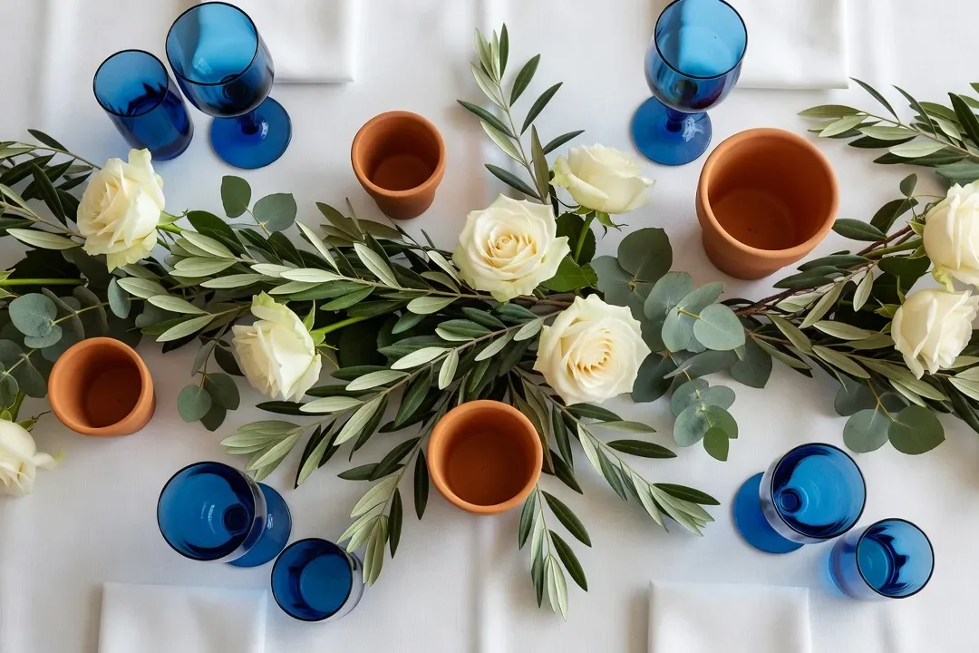 Table de mariage décorée en style Riviera avec floraux blancs et feuillage méditerranéen
